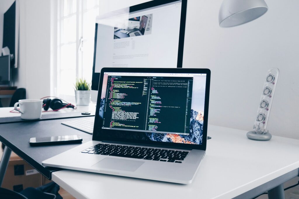 Laptop mit Code auf einem hellen Schreibtisch